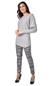 Front full body view of a woman wearing the frank lyman grey knit sweater and the frank lyman camo/grey denim pant. This pant is slim and has a silver foiled camo print.