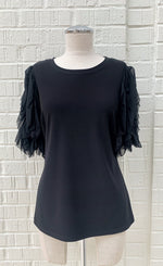 Load image into Gallery viewer, Front view of a mannequin wearing a black jersey knit top with sheer sleeves from Frank Lyman. The sheer sleeves are ruffled and 3/4 length.
