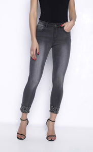 Front view of a woman wearing grey denim cropped jeans from Frank Lyman with rhinestone detailed cuffs.