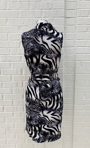 Back view of a mannequin wearing the Frank Lyman Wild Thing Dress. This dress features a navy, beige, and white animal print and zebra print mixed fabric and a fitted silhouette.