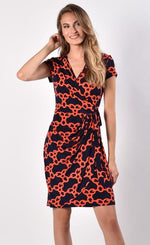 Load image into Gallery viewer, Front view of woman wearing navy and orange short sleeve chain print wrap dress from Frank Lyman
