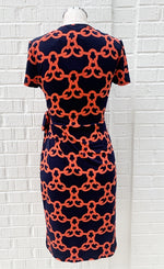 Load image into Gallery viewer, back view of navy and orange short sleeve chain print wrap dress from Frank Lyman on a mannequin
