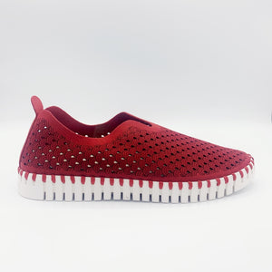 Outer view of the ilse jacobsen tulip flat in deep red. This flat shoe has a white sole and a scale-like red upper. The upper is perforated with tiny holes all over it.