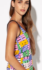 Load image into Gallery viewer, Right side top half view of a woman wearing the indies belem tank top. This tank top features a hashtag print made of purple, orange, green, and pink hashtags. The tank also features a v-neck and black trim around the neck and straps.
