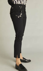 Load image into Gallery viewer, Right side bottom half view of a woman wearing a black top and the black indies epatant pants. These pants have two front patch pockets and a side chain on the right side. The pants are slightly cropped and sit above the ankles.
