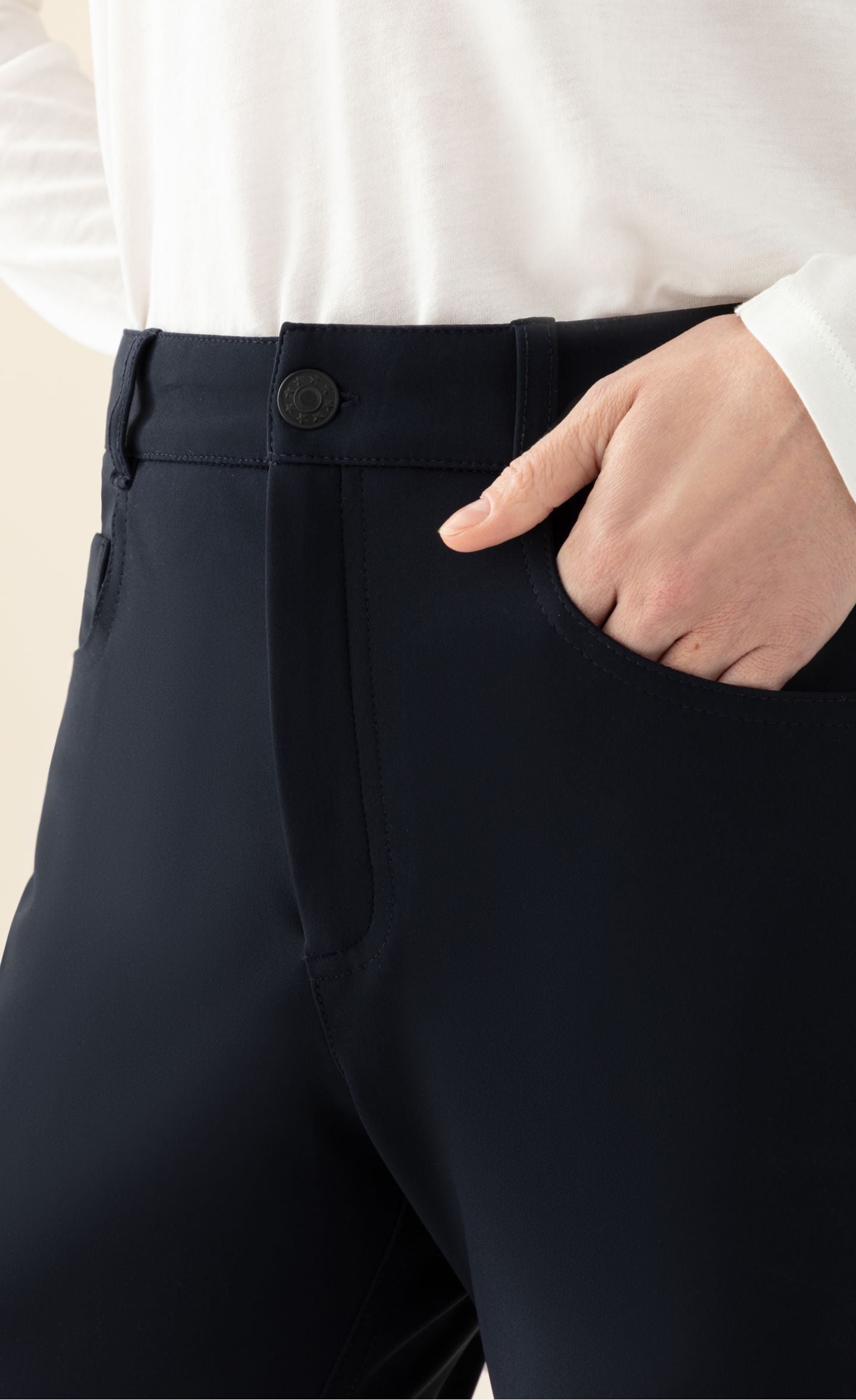 Front close up view of a woman wearing the indies navy joseph pants. These pants have a slim fit, a zip and button front, and two front italian pockets.