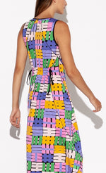 Load image into Gallery viewer, Back top half view of a woman wearing the Indies Nils Dress. This dress has multicolored hashtags printed all over it. It is sleeveless and the back of the neck and armholes are lined with black. The back features two adjustable ties at the waist to cinch it in.
