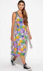 Load image into Gallery viewer, Front full body view of a woman wearing the Indies Nils Dress. This dress has multicolored hashtags printed all over it. It is sleeveless with a round neckline that is lined with black trim. The dress sits below the knees but above the ankles.
