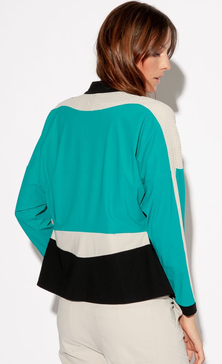 Back top half view of a woman wearing the Indies Nano Jacket. The back of the jacket has black bottom panel, a seafoam blue back, and pebble/beige perforated shoulders.