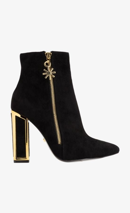Outer side view of the black kat maconie anges boot. This boot has a high heel and the heel is framed with gold. The outer side has a gold zipper with a star pull tab.