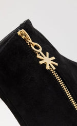 Load image into Gallery viewer, Outer side close up view of the black kat maconie anges boot. The outer side of the boot has a gold zipper with a star pull tab.
