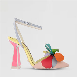 outer side view of the kat maconie rafi high heel pump. This high heel is in the color butter/ multi. The shoe has a pointed toe, an ankle strap, and a 3-D flower on the toe. 