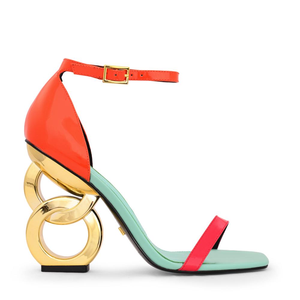 Outer side view of the kat maconie suzu high heel. This shoe has a blue/opal sole, an orange and pink patent leather upper with an adjustable ankle strap, and a gold chain-like heel.