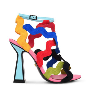 Outer side view of the kat maconie jihan high heel. This sandal shoe is made up of multi-colored, wave-like embroidered upper straps. The shoe features a blue ankle strap and a matching blue heel outlined with black.