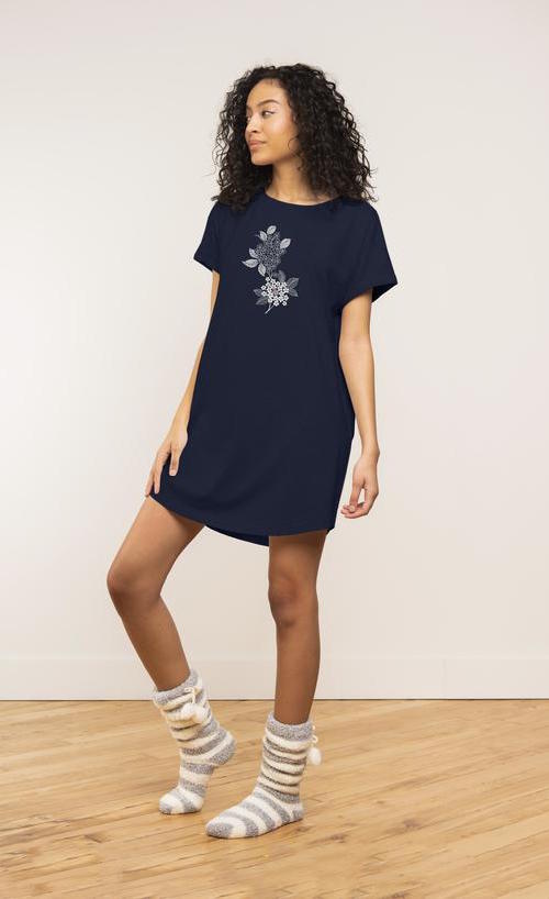 Front view of a woman wearing the coffee shoppe t-shirt dress. This t-shirt dress is navy with a floral print on it. 