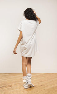 Back view of a woman wearing the coffee shoppe t-shirt dress. This short sleeve t-shirt dress is grey.