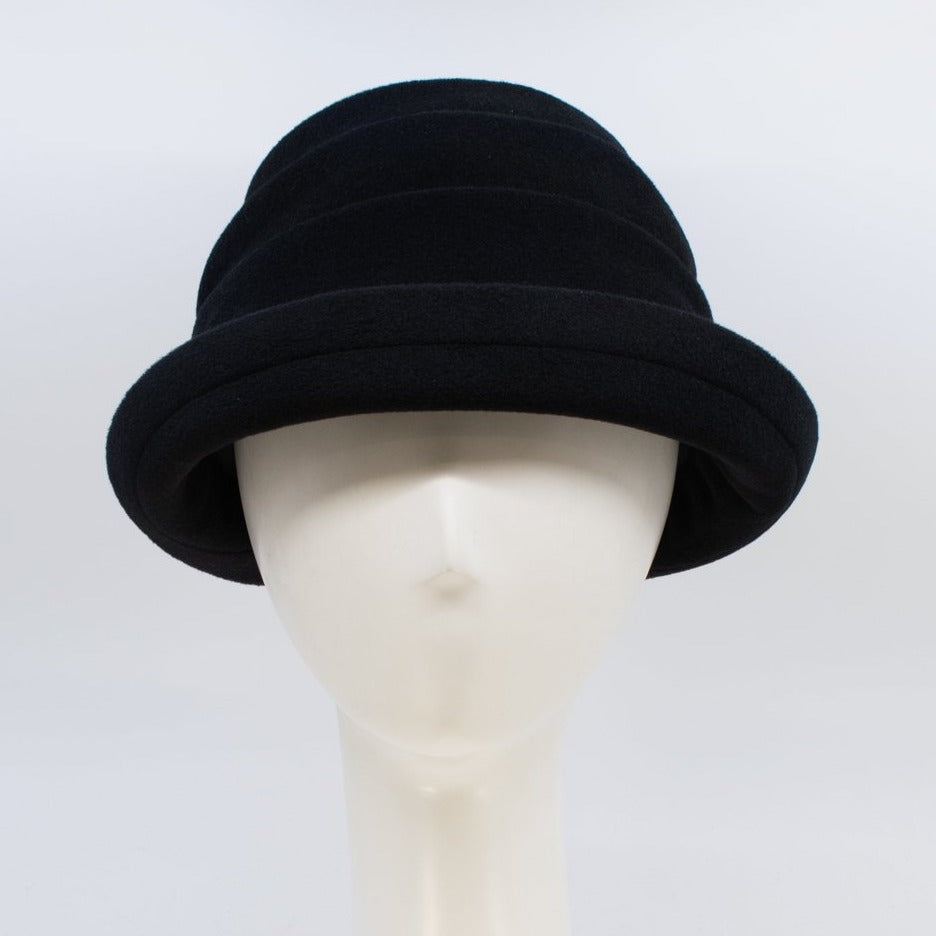 Front view of the lillie & cohoe beatrice hat. This hat is black with a tiered/folded crown and a rounded brim.