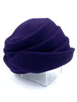 Load image into Gallery viewer, Right side view of the lillie &amp; cohoe boiled wool lexi purple hat. This has a tiered look on the crown and a folded brim that stitches up on the right side
