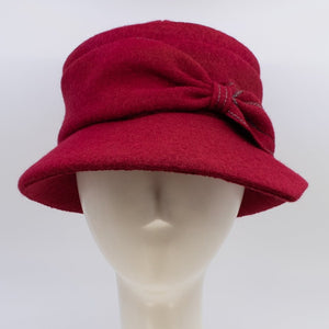 Front view of the lillie & Cohoe grace red/ruby hat. This hat has a pointed brim and a bow  in the front.