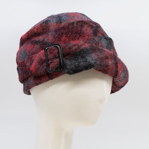 Front right side view of a the lillie & cohoe iconic prints lexi hat. This has has red and grey plaid and a tiered/folded crown. The right side of the hat has a decorative black buckle.