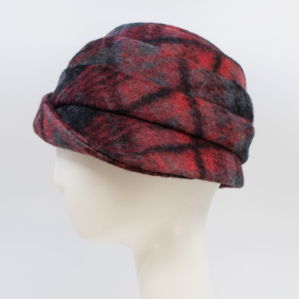 Left side view of a the lillie & cohoe iconic prints lexi hat. This has has red and grey plaid and a tiered/folded crown. The right side of the hat has a decorative black buckle.