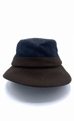 Load image into Gallery viewer, Front view of the lillie &amp; cohoe midnight/brown wool classic alexa hat. This hat is midnight blue on the top and dark brown on the bottom. The hat has a flat brim.
