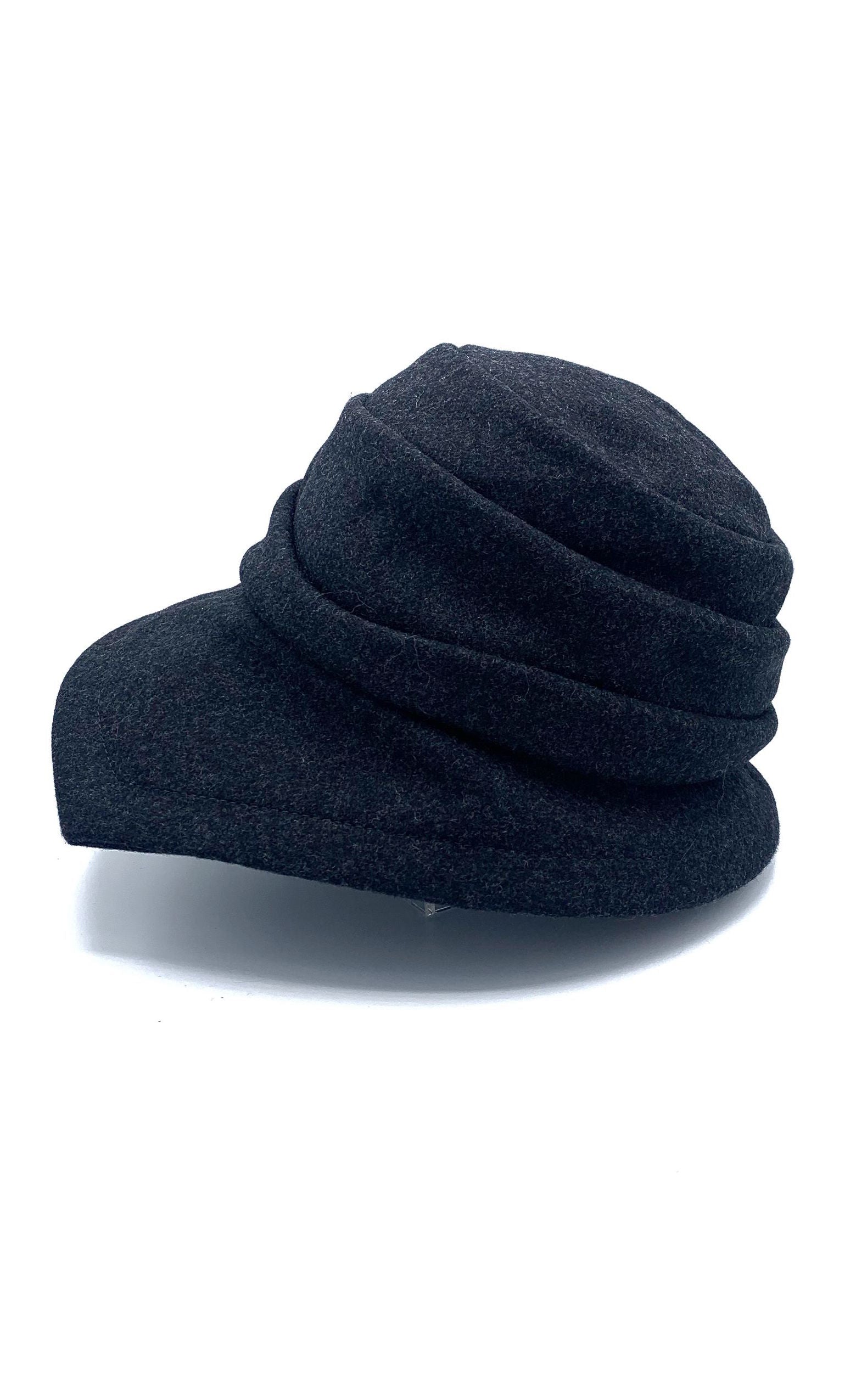 left side view of the lillie & cohoe midnight phoebe wool classic hat. This hat has a tiered/layered crown and an asymmetrical brim that points to the left.