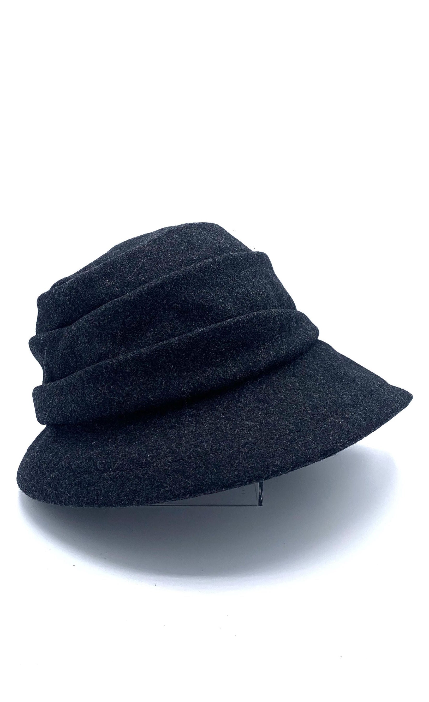 Right side view of the lillie & cohoe midnight phoebe wool classic hat. This hat has a tiered/layered crown and an asymmetrical brim that points to the left.