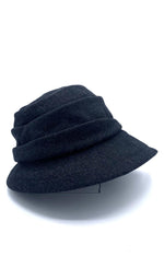 Load image into Gallery viewer, Right side view of the lillie &amp; cohoe midnight phoebe wool classic hat. This hat has a tiered/layered crown and an asymmetrical brim that points to the left.

