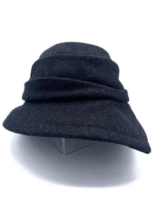 Front view of the lillie & cohoe midnight phoebe wool classic hat. This hat has a tiered/layered crown and an asymmetrical brim that points to the left.