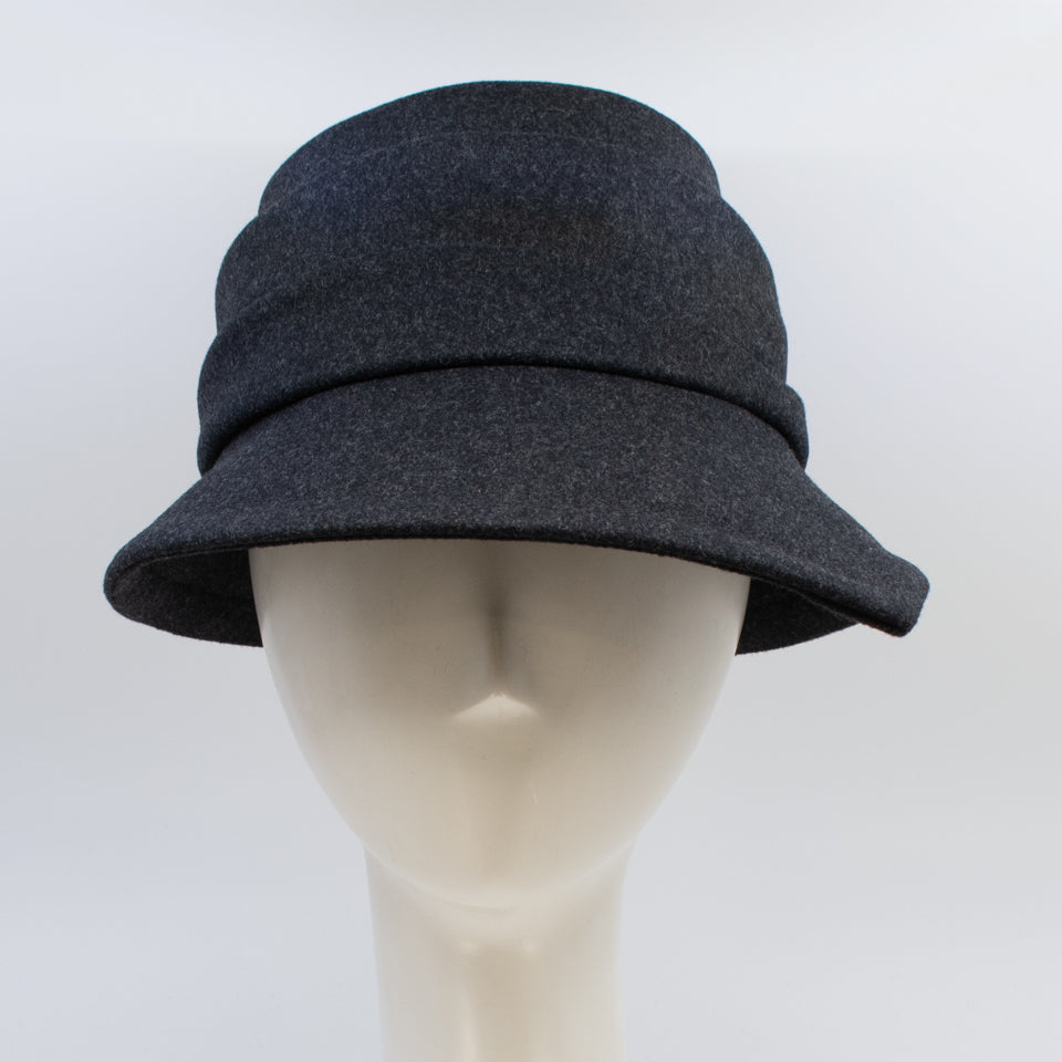 Front view of the lillie & cohoe midnight phoebe wool classic hat. This hat has a tiered/layered crown and an asymmetrical brim that points to the left.