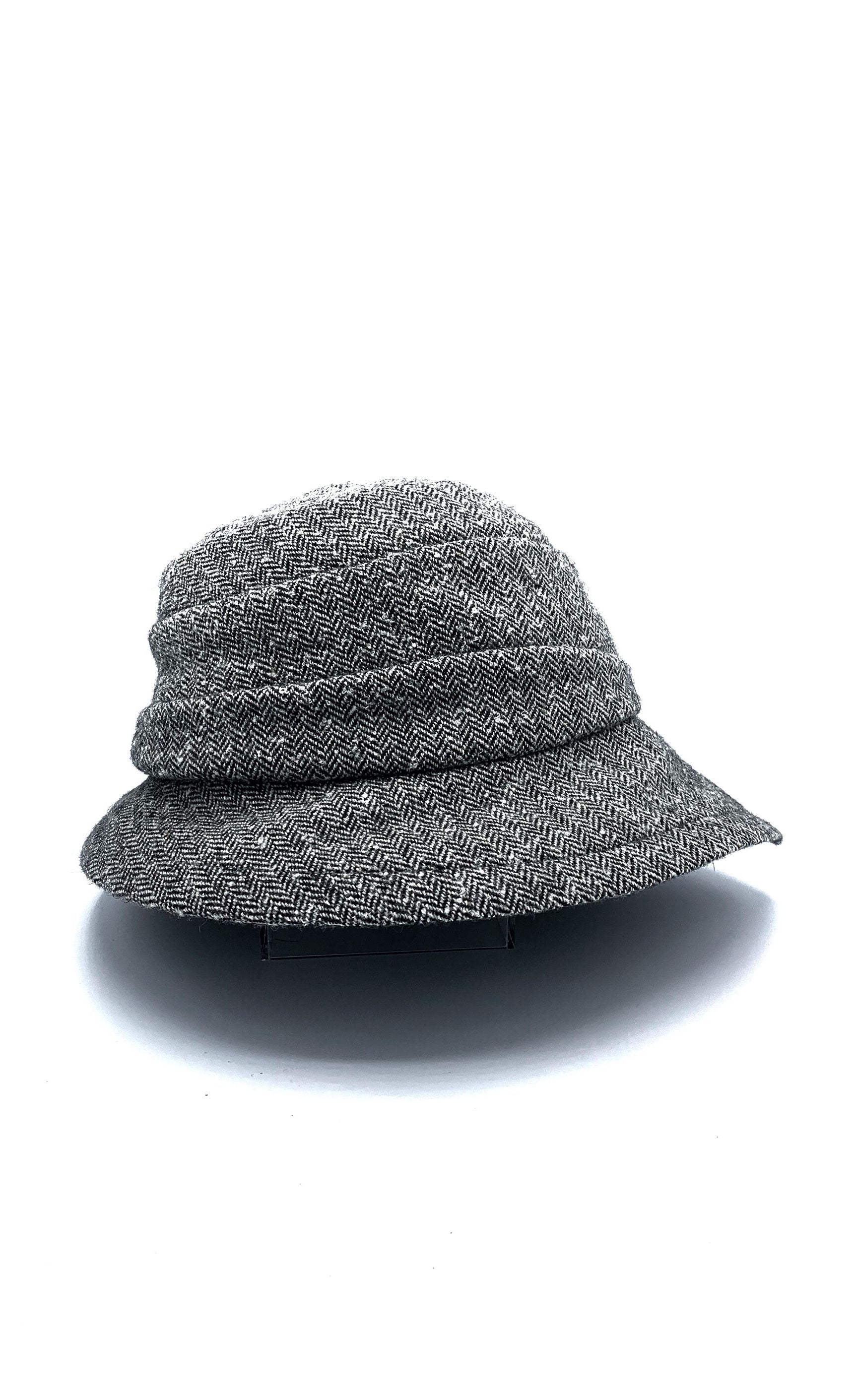 Right side view of the lillie & cohoe herringbone vintage phoebe hat. This hat has an asymmetrical pointed brim, a layered crown, and a grey herringbone pattern.
