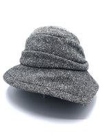 Load image into Gallery viewer, Front view of the lillie &amp; cohoe herringbone vintage phoebe hat. This hat has an asymmetrical pointed brim, a layered crown, and a grey herringbone pattern.
