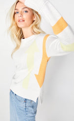 Load image into Gallery viewer, Front left-side top half view of a woman wearing jeans and the Lisa Todd Aim High Sweater. The sweater is white with a yellow arrow pointing up and an orange arrow on the side pointing down. The long sleeves have a yellow stripe and an orange stripe.
