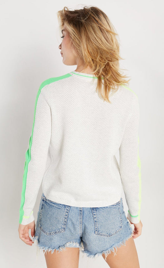 Back view of woman wearing lisa todd color pop sweater in the color mineral with lime trim.
