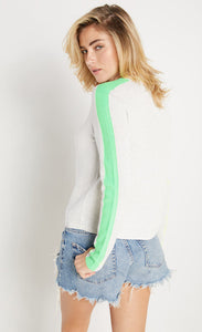 Back view of woman wearing lisa todd color pop sweater in the color mineral with lime trim.
