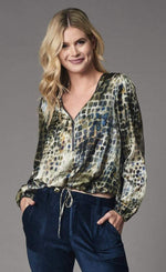 Load image into Gallery viewer, Front top half view of a woman wearing the lola &amp; Sophie alligator zip-neck top. This top is light green with a navy alligator print. It has a zip neckline, a drawstring hem, and banded long sleeves.
