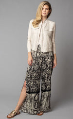 Load image into Gallery viewer, Front, full body view of a woman wearing the Lola &amp; Sophie animal border print pants and the Crinkle Linen Jean Jacket. The sand colored jacket features two front, fold over breast pockets, a zipper front, a linen body, and fitted long sleeves.
