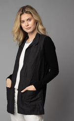 Load image into Gallery viewer, Front, close up view of a woman wearing the Lola &amp; Sophie Crinkle Linen Zip-Front Long Jacket. This jacket is black and has a flat collar, a zip up front, front pockets, and fitted long sleeves.
