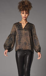 Load image into Gallery viewer, Front top half view of a woman wearing black leather pants and the lola &amp; Sophie green python top. This top has a v-neck, balloon sleeves, and a brown/green washed python print on it.

