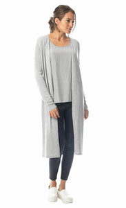 Front, full body view of a woman wearing a grey tank under the lola & sophie split back cardi. This cardigan is grey, draped open, and cuts off just below the model's knees. The long sleeves are fitted and ribbed. On the bottom the woman is wearing skinny black pants.