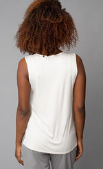 Load image into Gallery viewer, Back view of the top half of a woman wearing the Lola &amp; Sophie V-Neck tank. This tank is eggshell colored and has a cut that sits below the hips.
