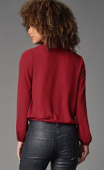 Load image into Gallery viewer, Back top half view of the Lola &amp; Sophie Zip Neck Double Georgette Top. This top is Garnet/Red colored. It has long sleeves with elastic cuffs, and a drawstring/tie hem.
