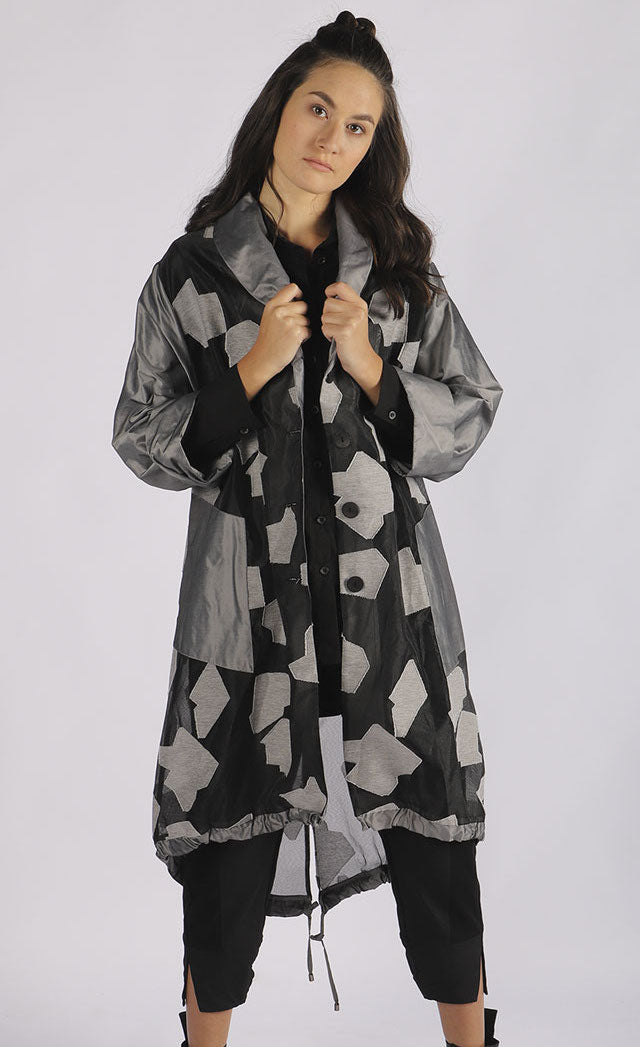 Front full body view of a woman wearing the luukaa abstract jacquard organza jacket. This mid-length jacket has a black see-through organza body with grey sleeves, a grey collar, grey pockets, and a grey abstract print.