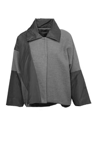 Front view of the luukaa short anthracite coat. This coat has a hidden front closure and an anthracite body with black puffer fabric on the flat collar and long sleeves. The black puffer fabric also runs diagonally across the body