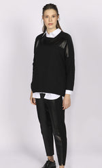 Load image into Gallery viewer, Front full body view of a woman wearing the luukaa faux leather top. This top is black with long sleeves and faux leather trim running horizontally across the top of the chest.
