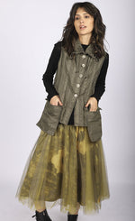 Load image into Gallery viewer, Front full body view of a woman wearing a brown vest over a black long sleeve top. On the bottom she is wearing the luukaa floral tulle skirt in khaki. This shirt has khaki tulle and a floral lining that shows through underneath. The skirt sits below the knees.
