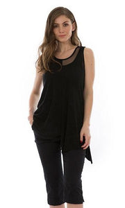 Front top half view of a woman wearing the luukaa half mesh tank. This tank is mainly mesh with a jersey patch on the top right side. It it black and layered over a black tank with black pants.