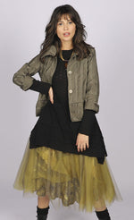 Load image into Gallery viewer, Front full body view of a woman wearing a brown jacket over a black long sleeve top. On the bottom she is wearing the luukaa floral tulle skirt in khaki. This shirt has khaki tulle and a floral lining that shows through underneath. The skirt sits below the knees.
