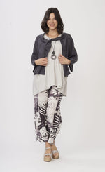 Load image into Gallery viewer, Front full body view of a woman wearing a white shirt with a grey jacket over it and the Luukaa Leaf Print Pant. The pant is wide leg with a white and lilac leaf print all over it.
